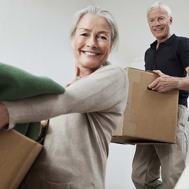 Couple carries moving boxes