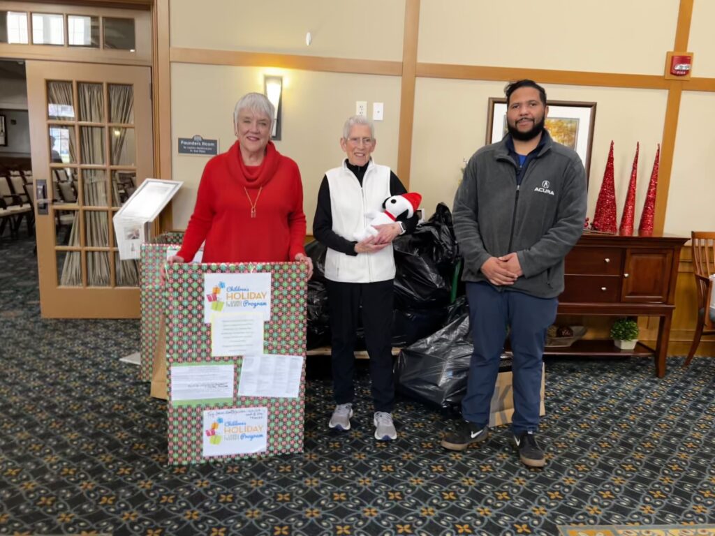 Shaker Pointe Residents Marsha Ras and Ronnie Uss with Chris of Northeast Acura in front of their pile of donations. 