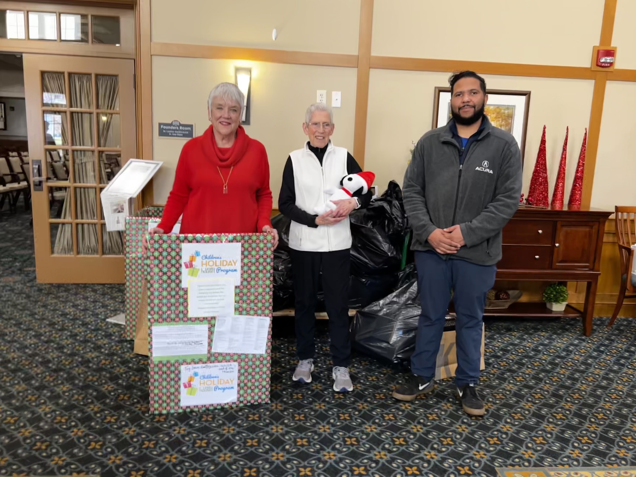 Shaker Pointe Residents Marsha Ras and Ronnie Uss with Chris of Northeast Acura in front of their pile of donations.